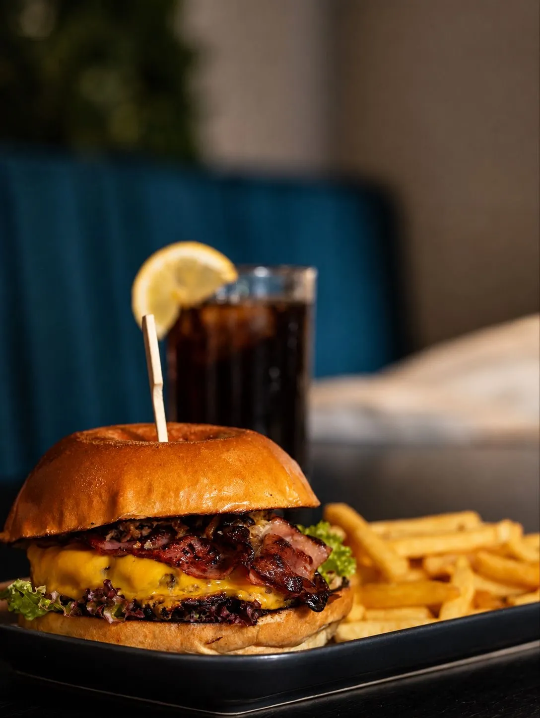 Burger mit Speck und Käse, daneben eine Cola