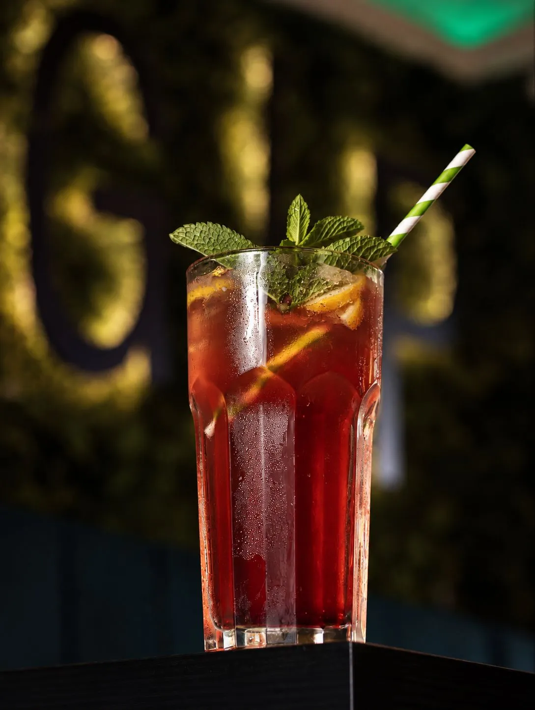 Rote Limonade mit Minze vor der Moos-Wand