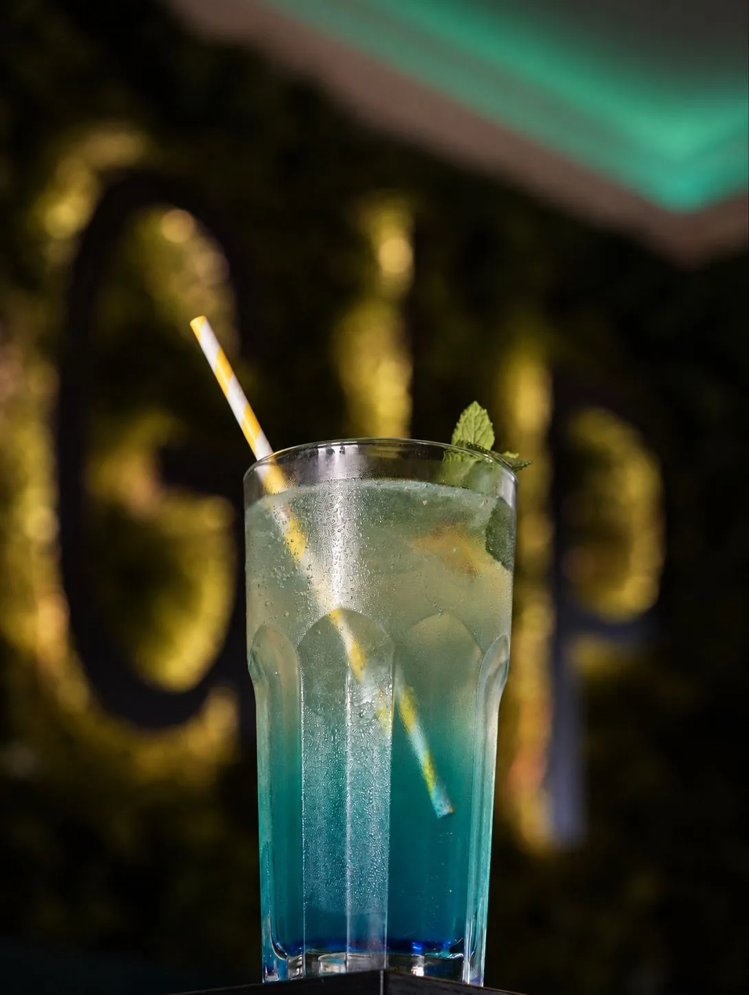 Blaue Limonade mit Zitrone vor der Moos-Wand