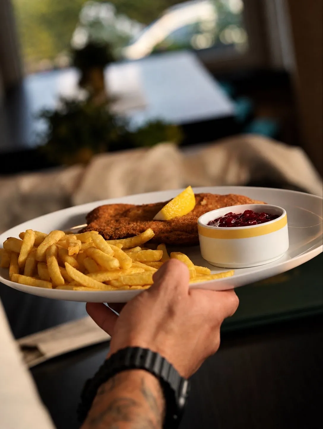 Schnitzel mit Pommes und Preiselbeeren wird serviert